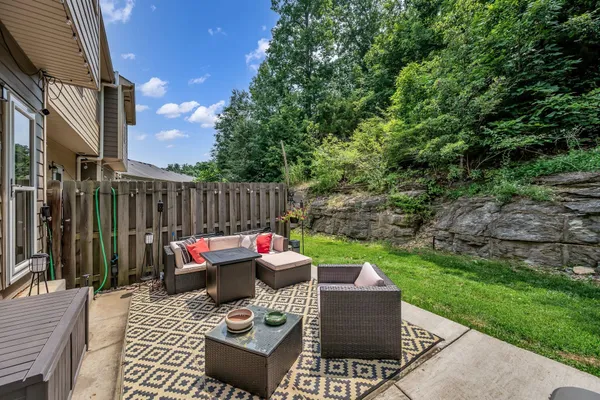 a view of a patio with couches a table and chairs and potted plants
