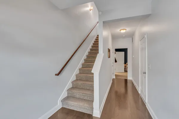 a view of a hallway with wooden floor and entryway