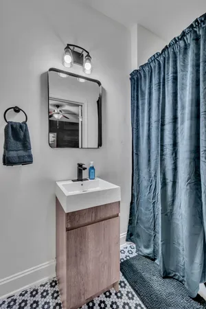a bathroom with a sink a mirror and shower curtain