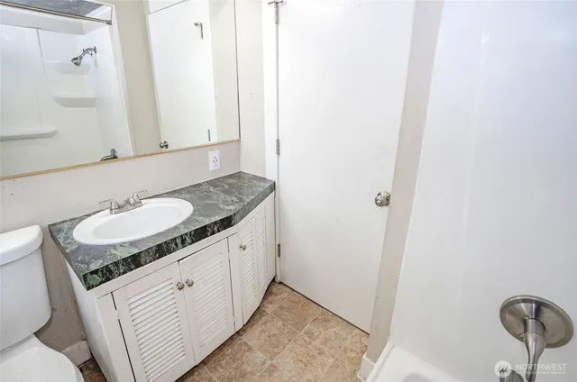 a bathroom with a granite countertop sink and a mirror
