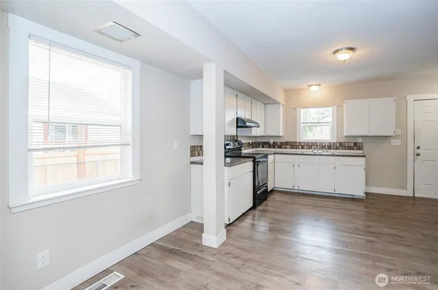 a kitchen with granite countertop white cabinets and white appliances