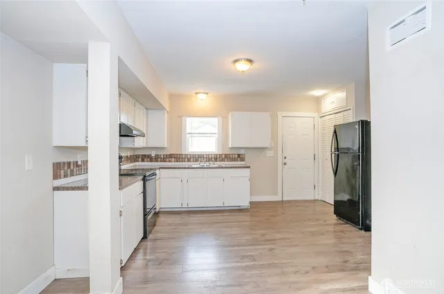 a kitchen with white cabinets and stainless steel appliances