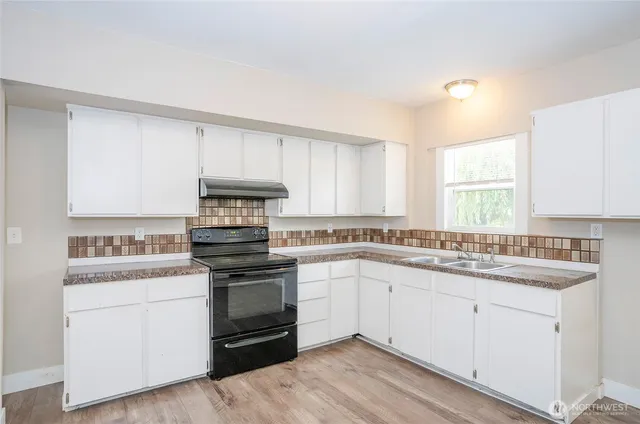 a kitchen with a sink stove and cabinets