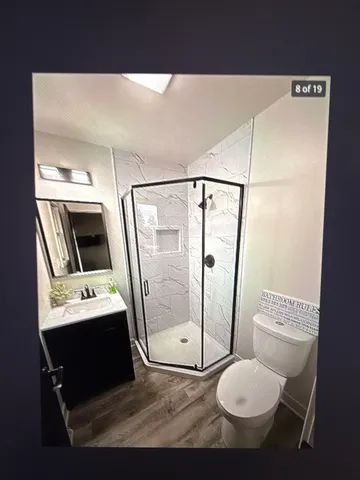 a bathroom with a toilet sink a mirror and shower