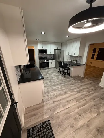 a kitchen with stainless steel appliances kitchen island granite countertop a sink a stove and cabinets