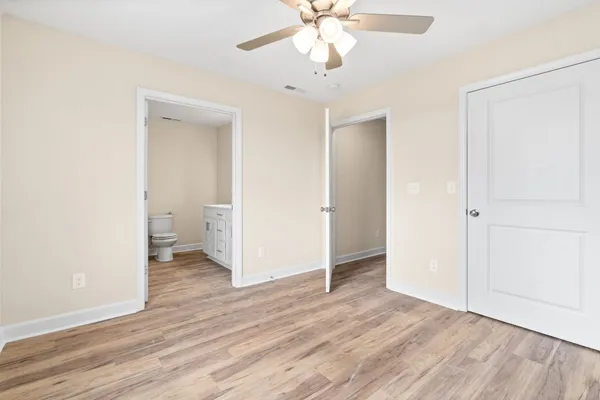 a view of a room with wooden floor and a ceiling fan