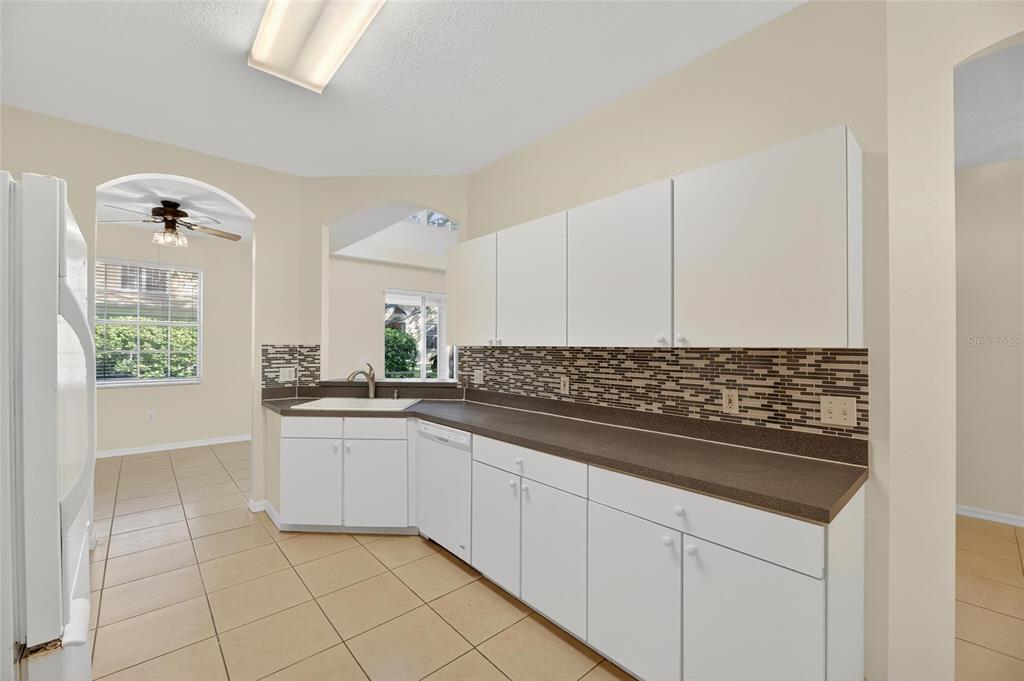6418 Rosefinch Court, Unit 103 Lakewood Ranch, FL 34202 - Photo 11 of 52 a kitchen with white cabinets and sink