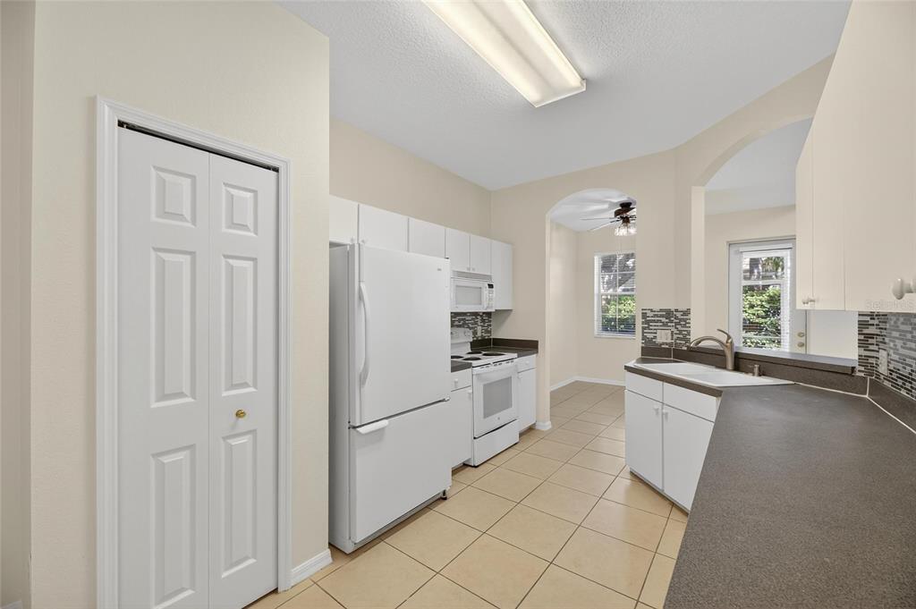 6418 Rosefinch Court, Unit 103 Lakewood Ranch, FL 34202 - Photo 12 of 52 a kitchen with white cabinets and stainless steel appliances