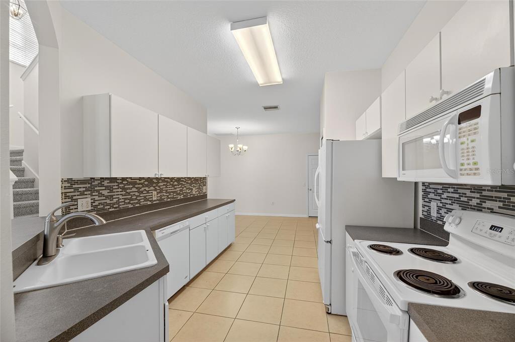 6418 Rosefinch Court, Unit 103 Lakewood Ranch, FL 34202 - Photo 14 of 52 a kitchen with granite countertop a sink stove and cabinets