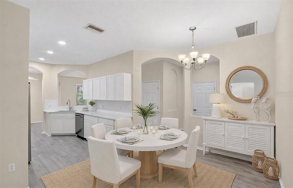 6418 Rosefinch Court, Unit 103 Lakewood Ranch, FL 34202 - Photo 2 of 48 a dining room with wooden floor a chandelier a wooden table and chairs