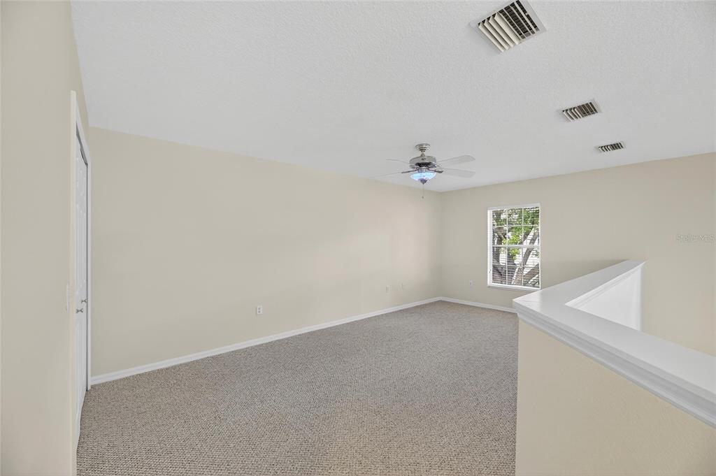6418 Rosefinch Court, Unit 103 Lakewood Ranch, FL 34202 - Photo 27 of 52 an empty room with windows and chandelier fan