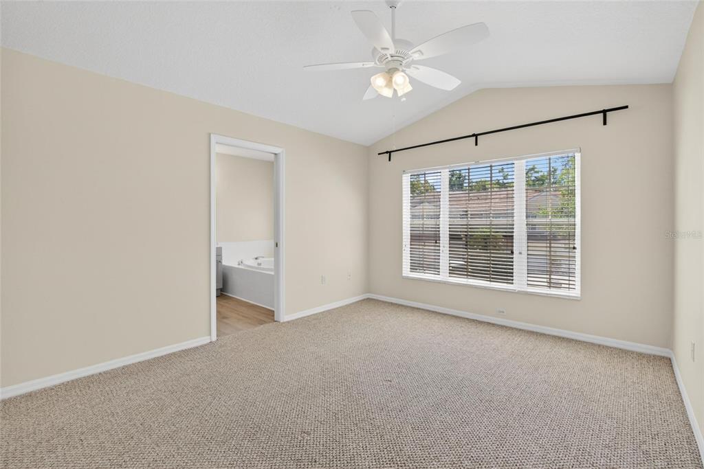 6418 Rosefinch Court, Unit 103 Lakewood Ranch, FL 34202 - Photo 28 of 48 an empty room with chandelier fan and windows
