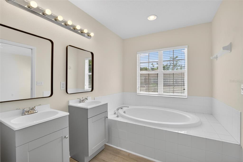 6418 Rosefinch Court, Unit 103 Lakewood Ranch, FL 34202 - Photo 31 of 48 a bathroom with a tub a sink and mirror