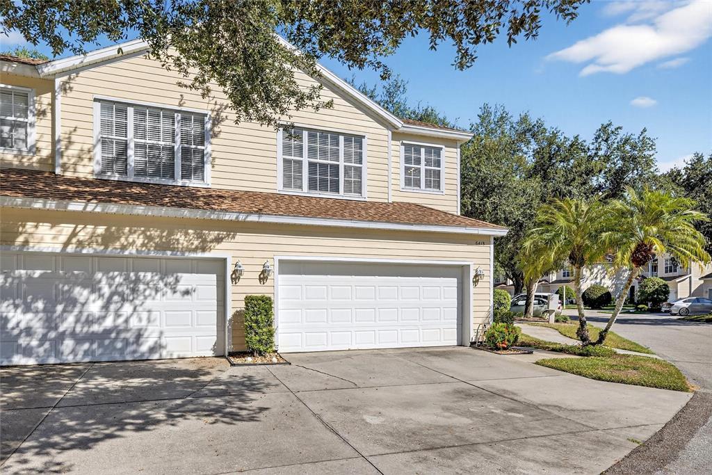 6418 Rosefinch Court, Unit 103 Lakewood Ranch, FL 34202 - Photo 46 of 52 a view of a house with a yard and garage