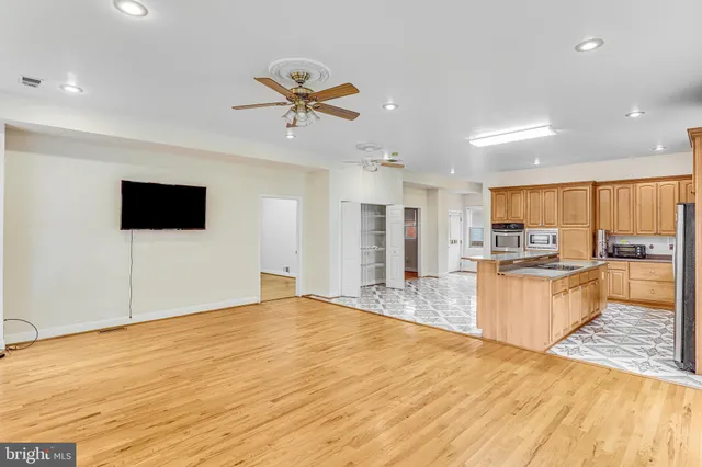 a large kitchen with stainless steel appliances kitchen island a large counter top a sink appliances and cabinets