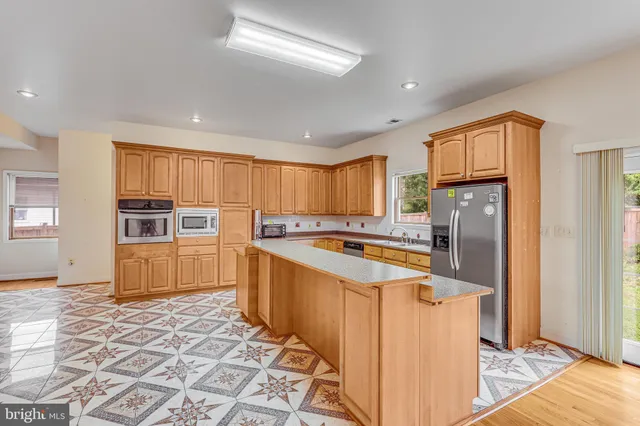 a kitchen with stainless steel appliances granite countertop a refrigerator and a stove top oven