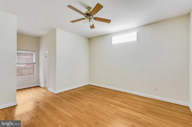 a view of a big room with wooden floor and a ceiling fan
