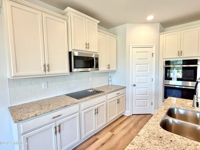 a kitchen with stainless steel appliances granite countertop white cabinets and a granite counter tops