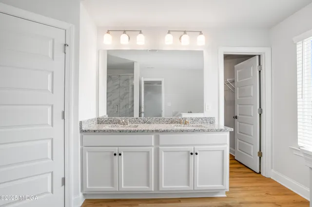 a bathroom with a granite countertop sink and a mirror