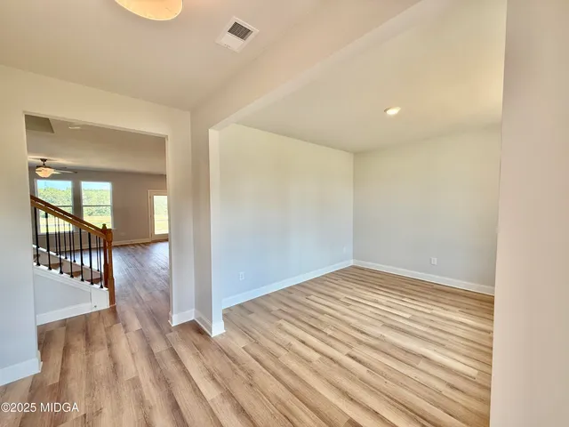 a view of a hallway with wooden floor and windows
