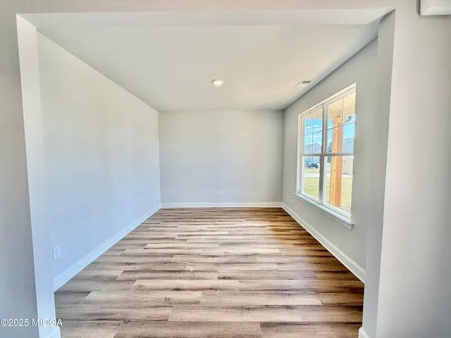 a view of a room with wooden floor and window