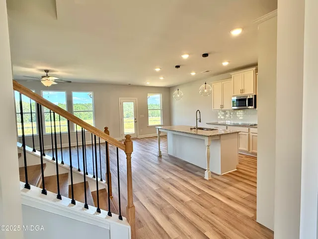 a open kitchen with white cabinets and wooden floor