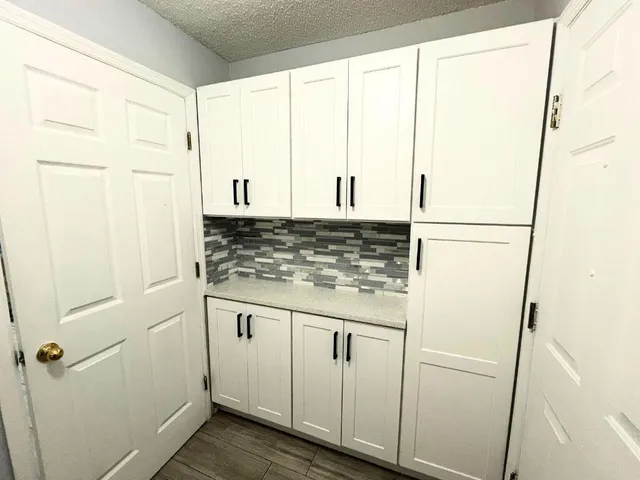 a kitchen with stainless steel appliances white cabinets and a gate