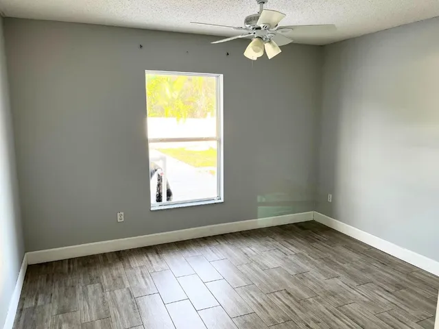an empty room with a window and wooden floor