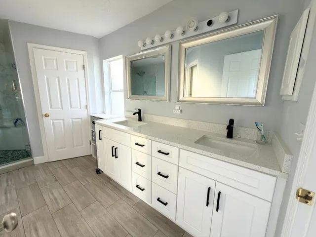 a bathroom with a double vanity sink mirror and