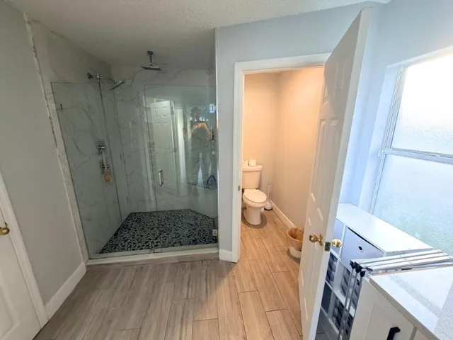 a bathroom with a granite countertop shower and a sink