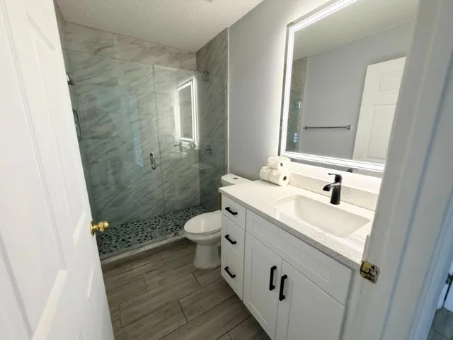 a bathroom with a sink a toilet and shower