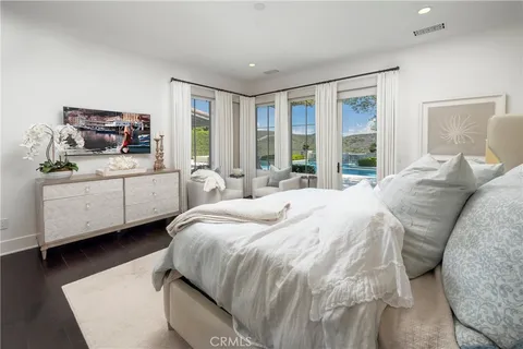 a bedroom with a bed a window and a television