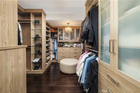 a view of walk in closet with clothes and shoes