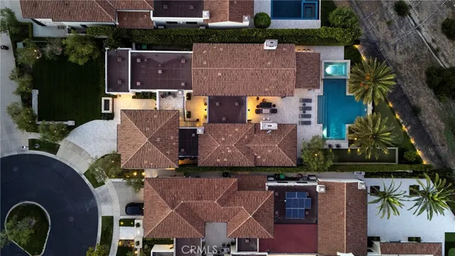 an aerial view of residential houses with outdoor space and parking