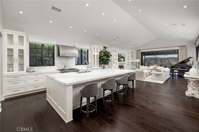 a open kitchen with stainless steel appliances granite countertop a stove and a wooden floors