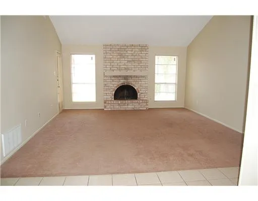 a view of empty room with a fireplace