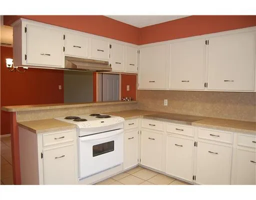 a kitchen with stainless steel appliances granite countertop a stove a sink and a white cabinets