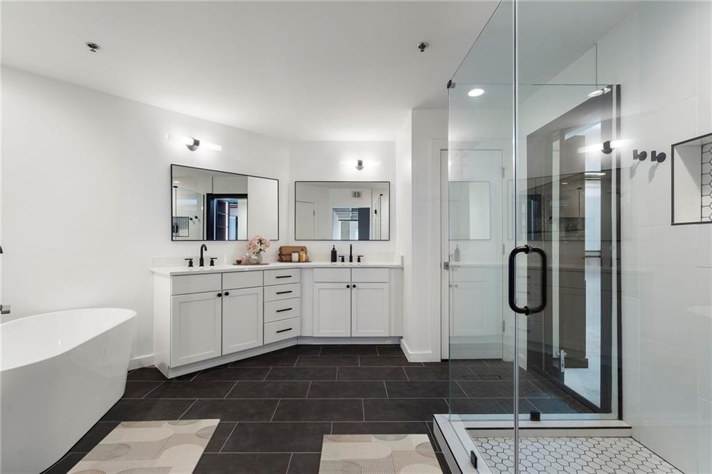 260 18th Street Northwest, Unit 10224 Atlanta, GA 30363 - Photo 17 of 47 a bathroom with a tub shower sink and mirror
