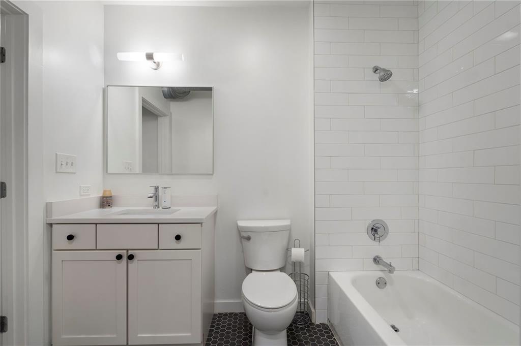 260 18th Street Northwest, Unit 10224 Atlanta, GA 30363 - Photo 26 of 47 a bathroom with a bathtub sink mirror and toilet