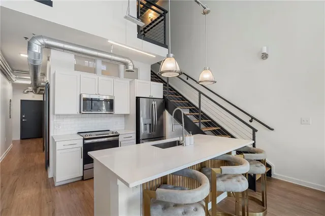 a kitchen with stainless steel appliances kitchen island a table and chairs