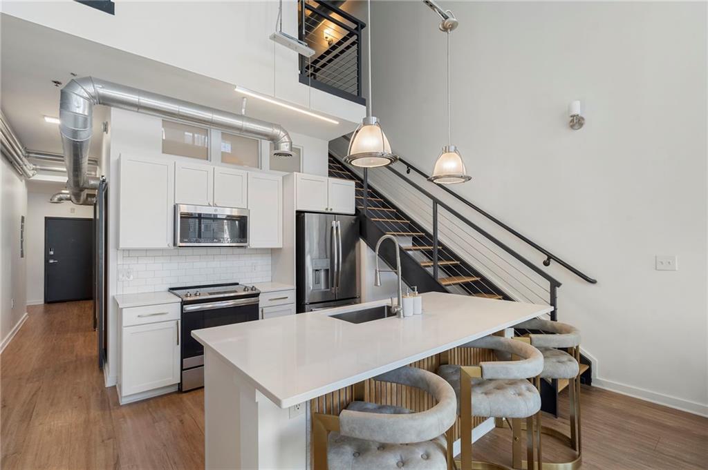 260 18th Street Northwest, Unit 10224 Atlanta, GA 30363 - Photo 4 of 47 a kitchen with stainless steel appliances kitchen island a table and chairs
