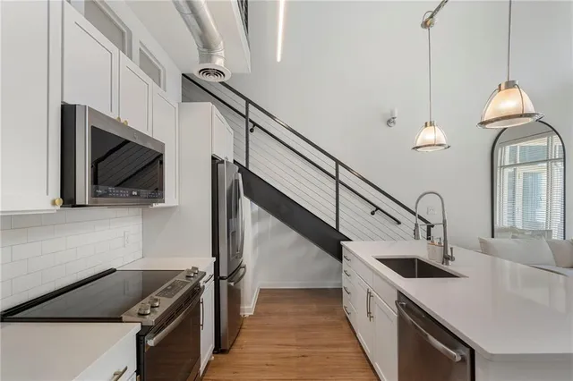 a kitchen with stainless steel appliances kitchen island a stove a sink and a microwave