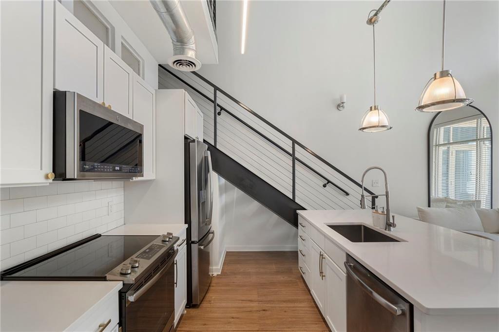 260 18th Street Northwest, Unit 10224 Atlanta, GA 30363 - Photo 5 of 47 a kitchen with stainless steel appliances kitchen island a stove a sink and a microwave