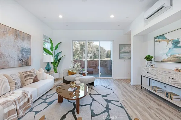 a living room with furniture and window with potted plants