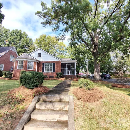 a front view of a house with a yard and trees