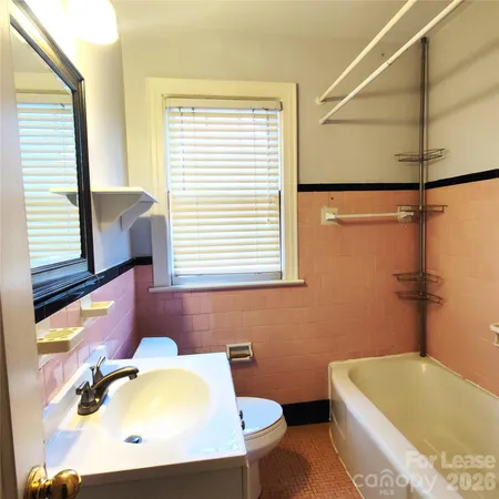 a bathroom with a tub a sink and a window