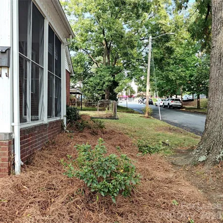 a view of a house with backyard and trees