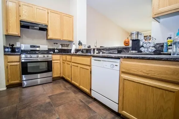 a kitchen with stainless steel appliances granite countertop a stove a sink and a microwave