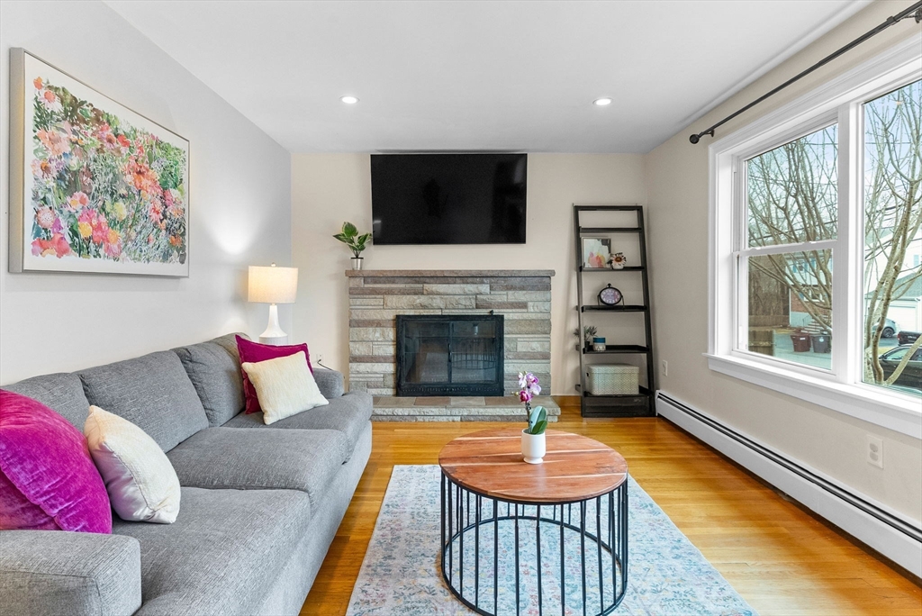 60 Goshen Road Dedham, MA 02026 - Photo 3 of 37 a living room with furniture a flat screen tv and a fireplace