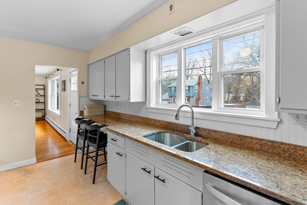 60 Goshen Road Dedham, MA 02026 - Photo 9 of 37 a kitchen with stainless steel appliances granite countertop a sink a stove and a granite counter tops with white cabinets